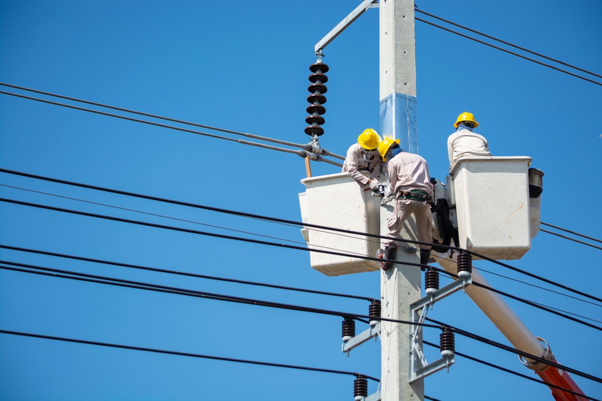 Copperline electrician on a ladder wiring a fixture