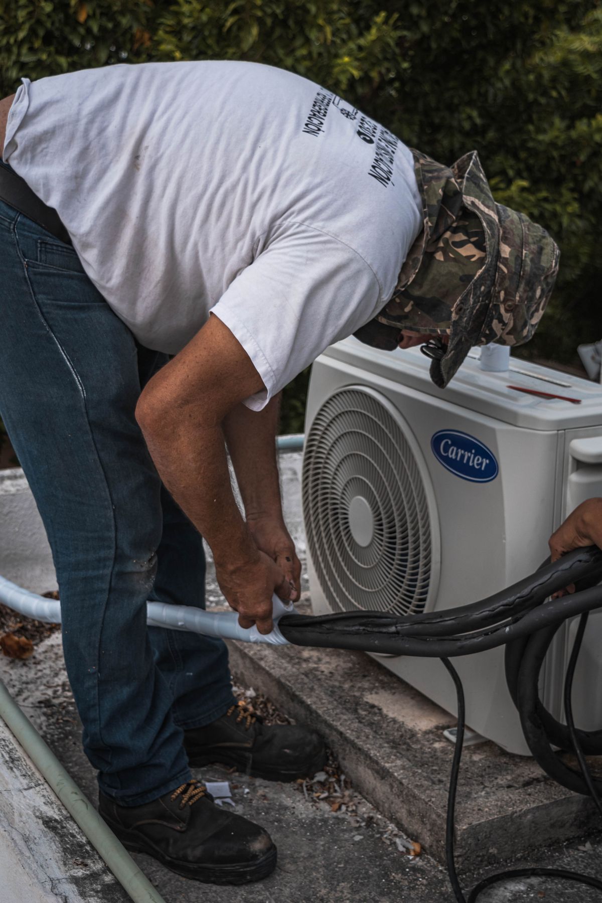 NATE-certified technician servicing an outdoor AC condenser unit