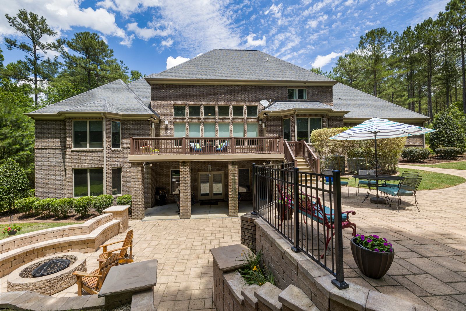 Premium backyard with multi-level stone patio, fire feature and lush landscaping